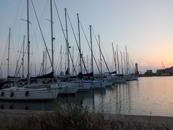 Sailboats moored in sea against clear sky