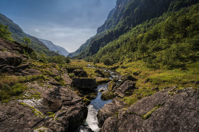 Scenic view of river amidst mountains against sky