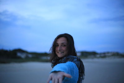 Portrait of smiling woman against sky