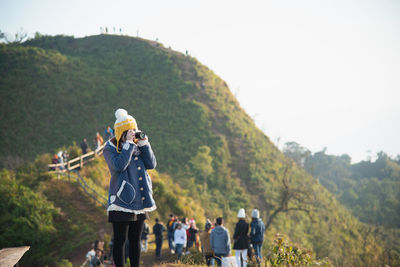 Hiker clicking picture by camera against clear sky