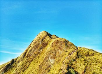 Low angle view of rocks against blue sky