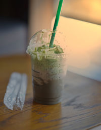 Close-up of plastic cup drink on table