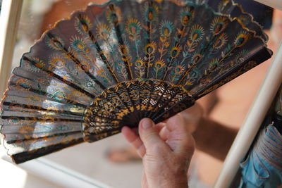 Close-up of hand holding hand fan