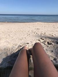 Low section of woman relaxing on beach