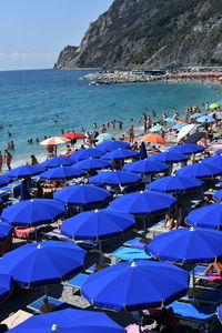 High angle view of parasols and people on beach against sky