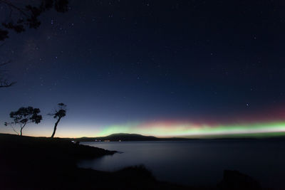Scenic view of lake against sky at night
