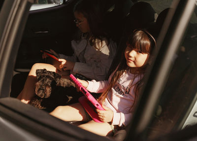 Side view of woman sitting in car