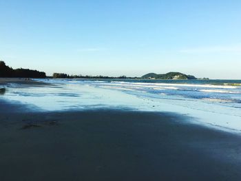 Scenic view of beach against blue sky