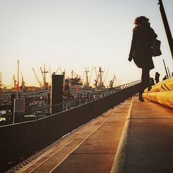 Man in city against sky during sunset