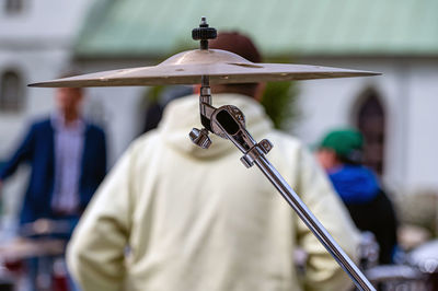 Part of a drum kit on a defocused background with a human silhouette, closeup