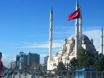 Flag in city against sky