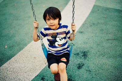 High angle view of girl on swing at playground