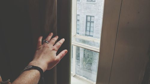 Close-up of hand on window