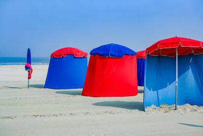 Multi colored umbrella on beach against clear blue sky