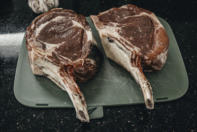 Two cuts of rib eye beef steak on cutting board