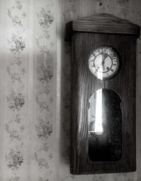 Close-up of clock mounted on wall at home