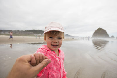 Portrait of smiling girl on beach against sky