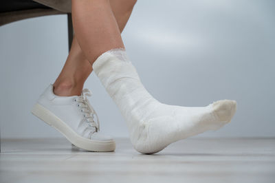 Low section of woman dancing on white background