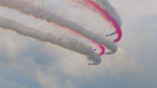 Low angle view of airshow against sky