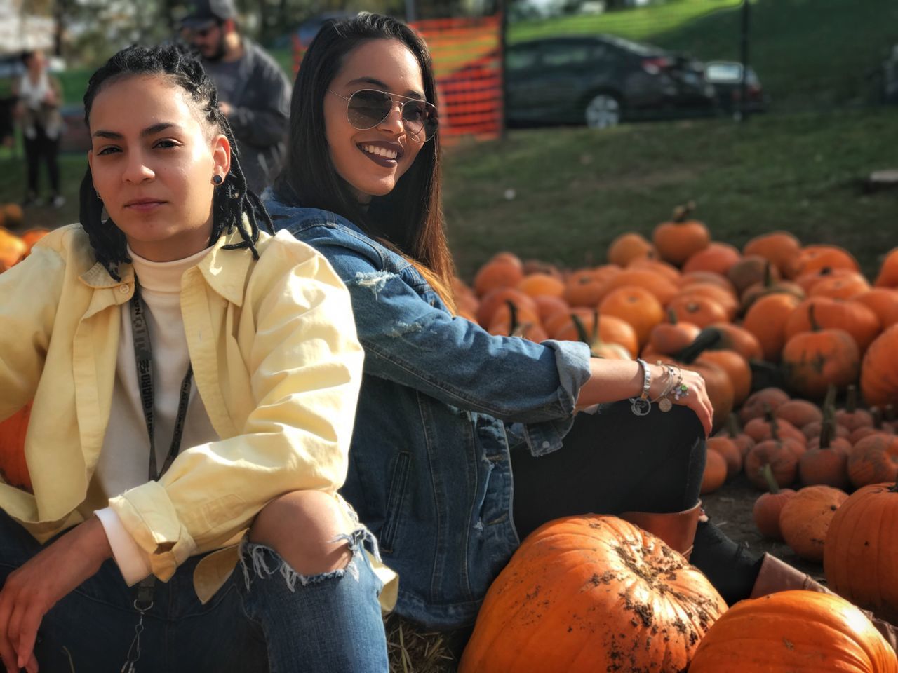 looking at camera, young adult, portrait, young women, pumpkin, smiling, casual clothing, front view, real people, standing, two people, lifestyles, outdoors, happiness, friendship, day, halloween, leisure activity, togetherness, beautiful woman, people