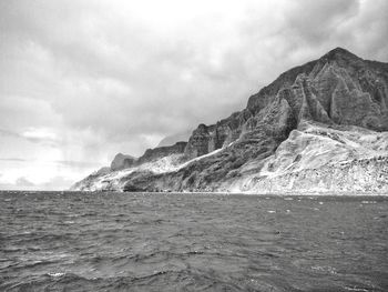 Scenic view of sea and mountains against sky