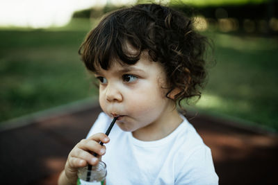 Portrait of cute boy looking away outdoors