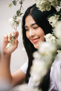 Portrait of a smiling young woman holding flowering plants