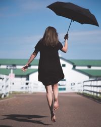 Rear view of woman standing in sea against sky