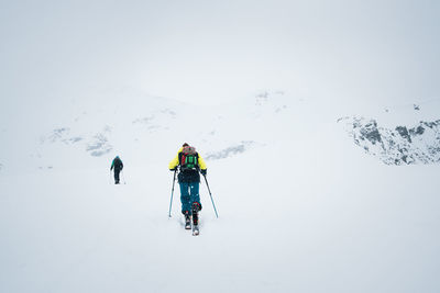 Rear view of man skiing on snow covered land