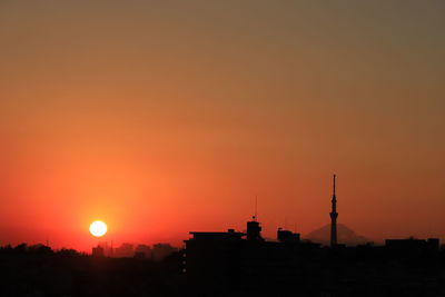 Silhouette buildings against sky during sunset