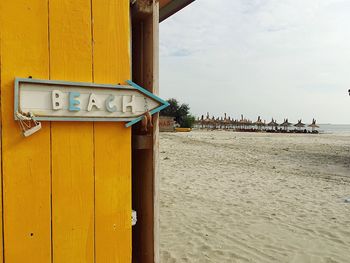 Lifeguard hut on beach against sky