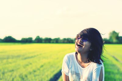 Portrait of young woman on field