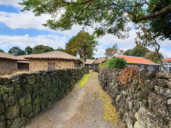 Footpath amidst buildings against sky