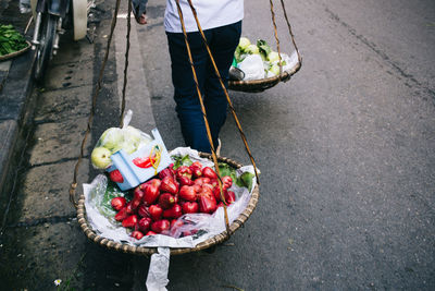 Low section of man holding fruits in basket