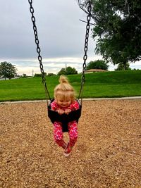 Full length of woman on swing in playground