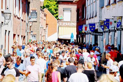 Rear view of people standing on city street