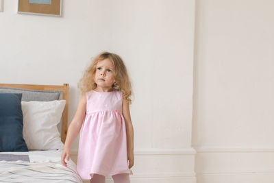 Charming child in pink dress at home