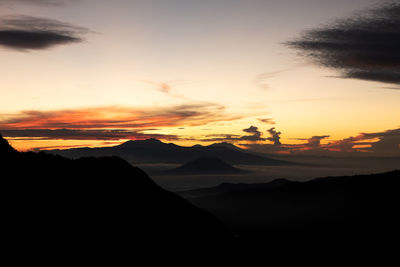 Scenic view of silhouette mountains against sky during sunset