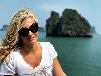 Portrait of woman wearing sunglasses against sea