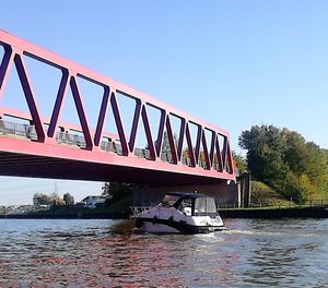 Bridge over river against clear blue sky