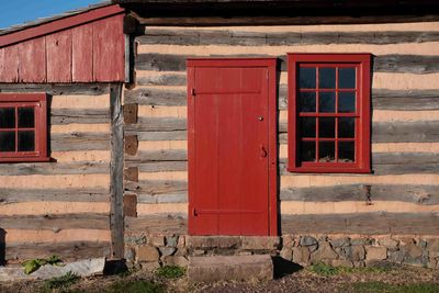 Colonial pennsylvania log cabin rustic exterior with red window and door