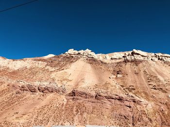 Scenic view of desert against clear blue sky