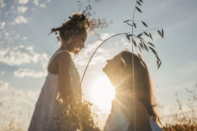 Side view of woman standing on field against sky