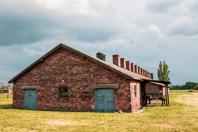 Old house on field against sky