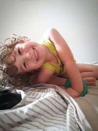 Portrait of smiling woman relaxing on bed