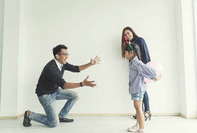 Young couple standing against wall