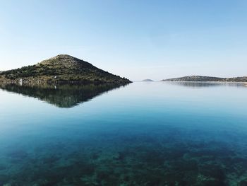 Scenic view of lake against clear blue sky