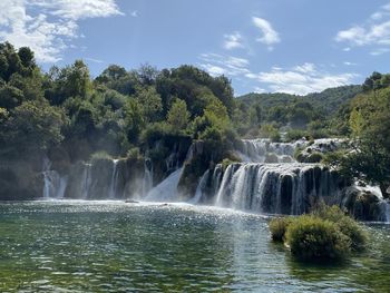 Scenic view of waterfall against sky