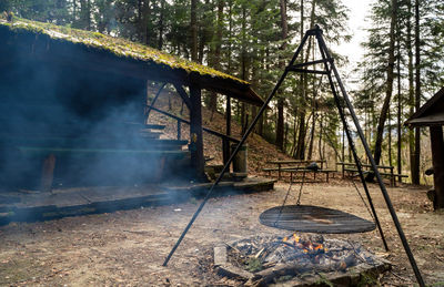 Bonfire at a rural farm setting in a middle of a forest against abandoned hut or barn