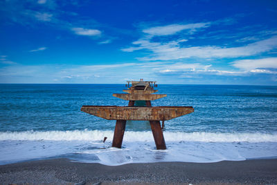 Lifeguard hut on beach against sky